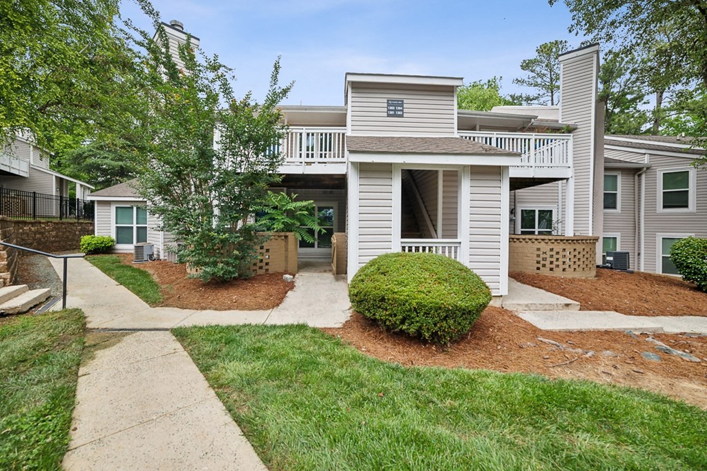 a walkway in front of a white house with a porch