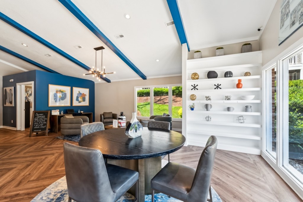 A modern dining room with a round table and chairs. at Woodcreek Apartments, North Carolina