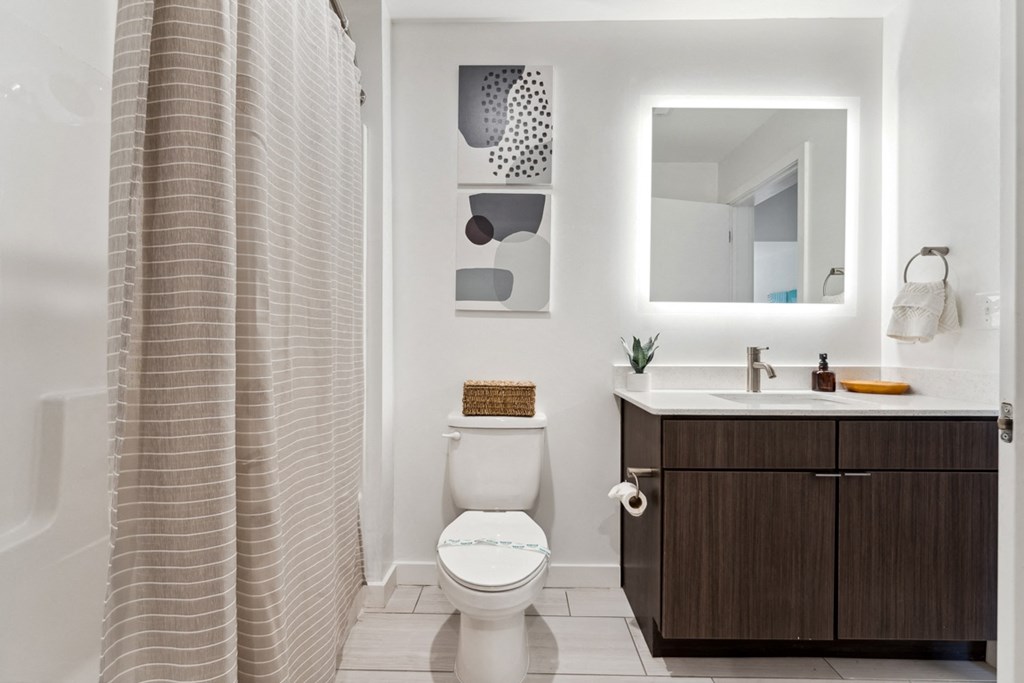a bathroom with a white sink and toilet next to a bathtub with a shower curtain at Hydro, Richmond, VA
