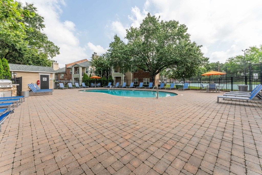 a swimming pool with chaise lounge chairs and trees in the background  at Willow Ridge Apartments, Charlotte, 28210