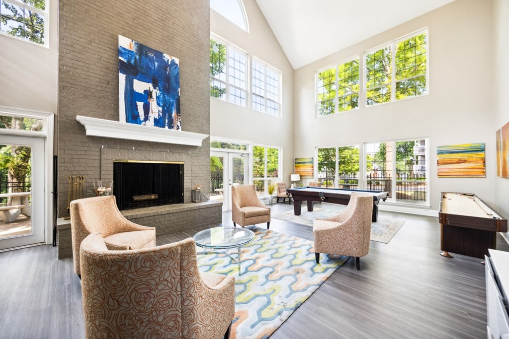 a living room with a large fireplace and a pool table at River Oak Apartments, Louisville, Kentucky