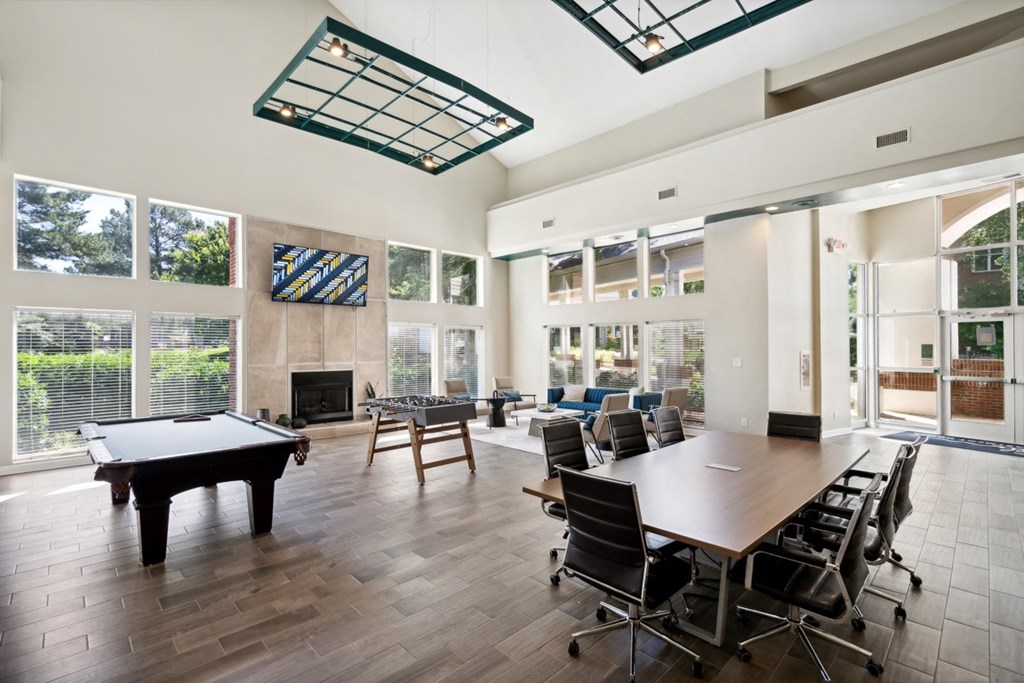 a conference room with a pool table and tables and chairs at The Falls Apartments in Raleigh NC