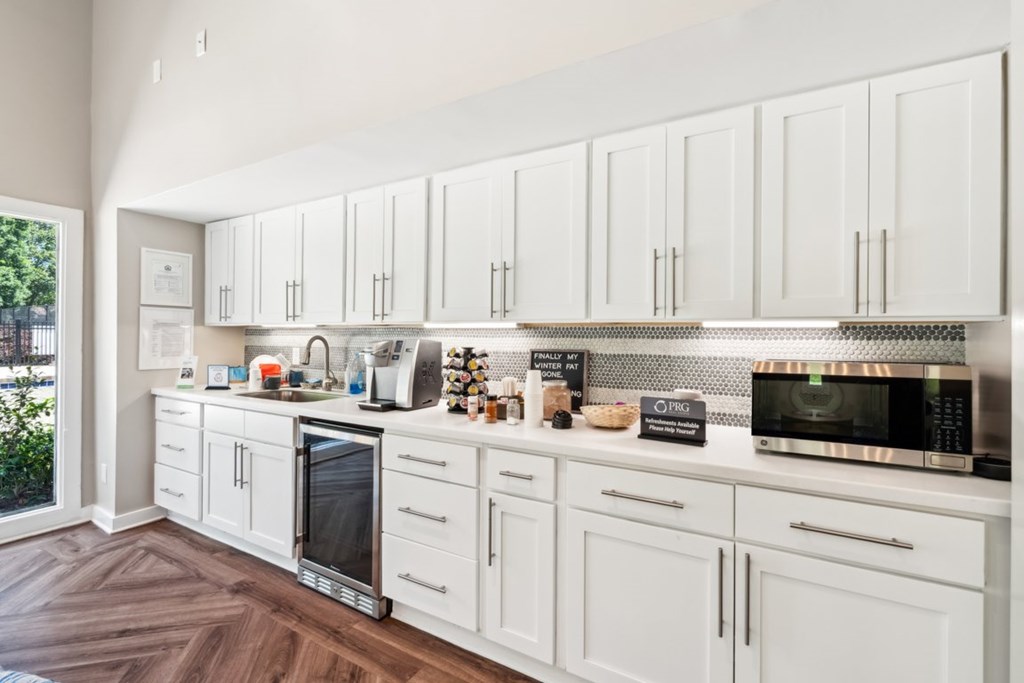 A kitchen with white cabinets and a wood floor. at Woodcreek Apartments, Cary, NC, 27511