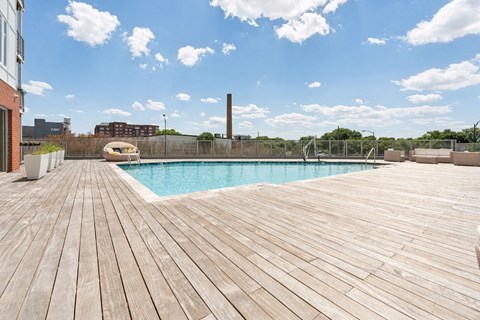 a swimming pool on a wooden deck next to a building
