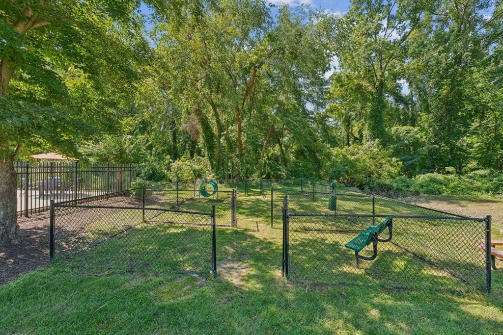 A park with a green bench and a fence at Staples Mill Townhomes Apartments, Richmond