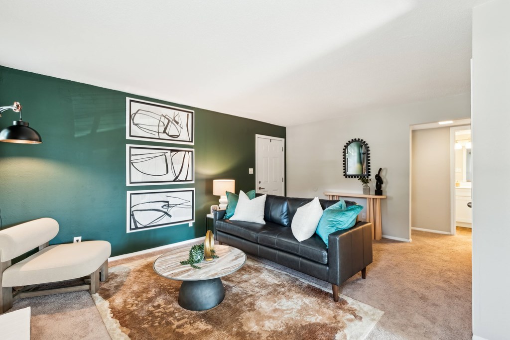 A living room with a black couch and a brown rug. at Woodcreek Apartments, Cary 27511