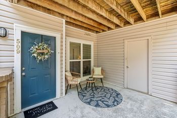 A blue door with a wreath on it and a sign that says "Welcome Home" on the mat.