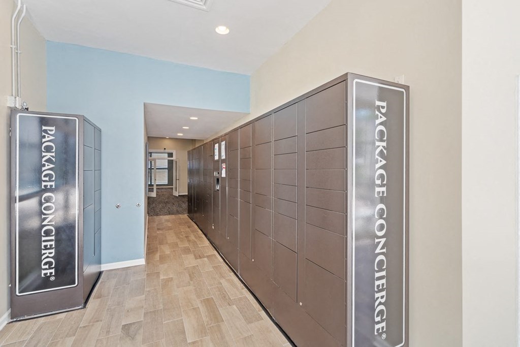 a communal elevator lobby in a building with wood floors and blue walls at The Falls Apartments in Raleigh NC