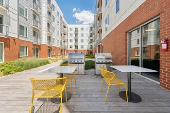 A patio with a table and chairs is surrounded by buildings.