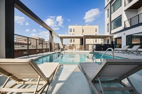 the pool area of a building with a swimming pool and lounge chairs  at The Box, Virginia, 23224