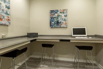 a computer desk in a room with three stools  at Park Ridge Estates, Durham, North Carolina