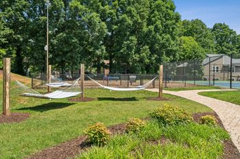 A playground with a swing set and a basketball court. at Woodcreek Apartments, Cary, North Carolina