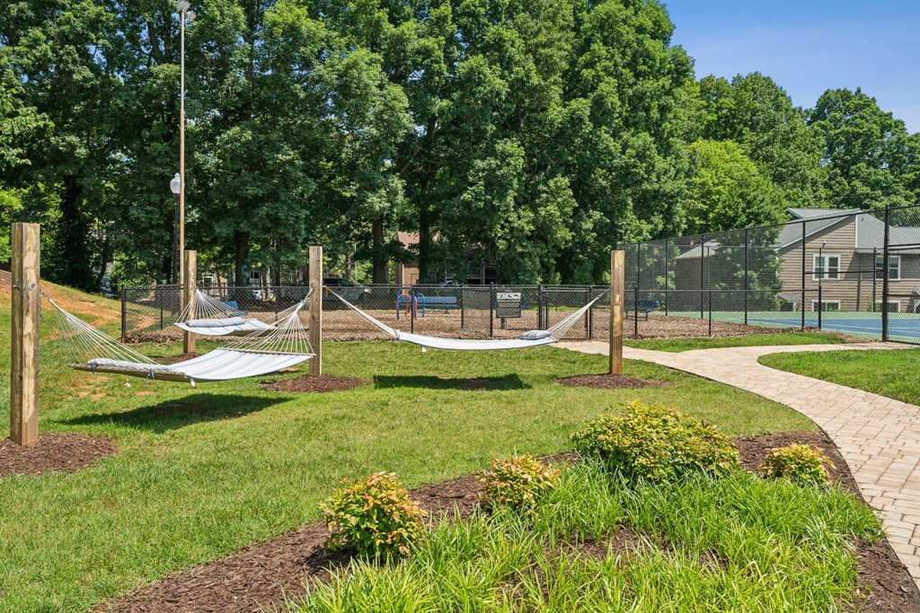 A playground with a swing set and a basketball court at Woodcreek Apartments, Cary, NC, 27511