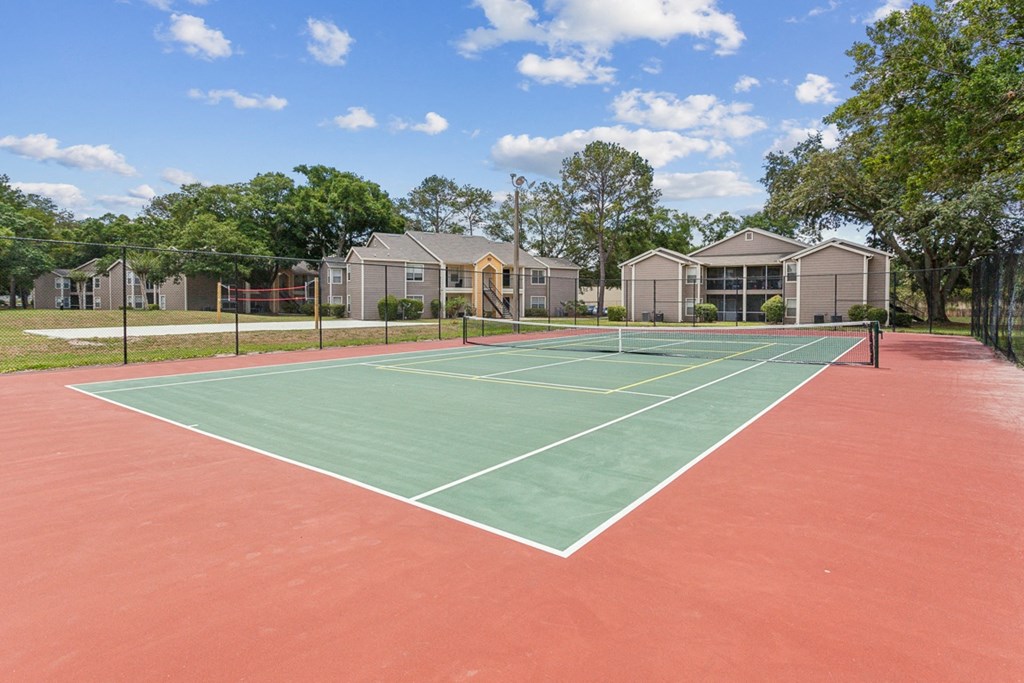 a tennis court with apartments in the background  at Palm Crossing, Florida