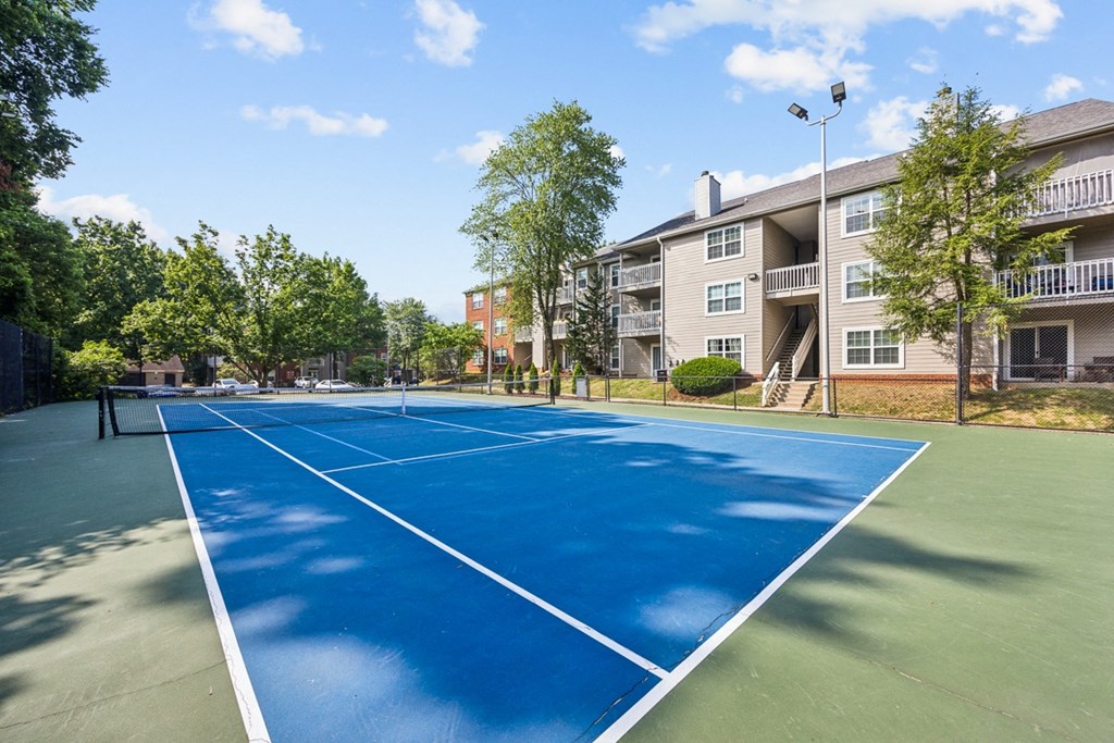 a tennis court with an apartment building in the background at River Oak Apartments, Louisville, KY, 40206