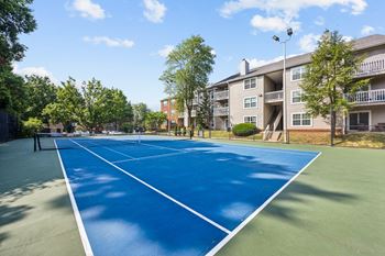 a tennis court with an apartment building in the background at River Oak Apartments, PRG Real Estate, Kentucky, 40206