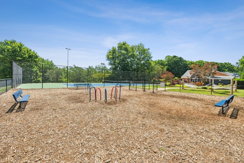 A playground with a swing set and a slide. at Woodcreek Apartments, Cary, NC