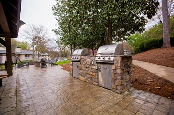 a stone outdoor kitchen with two grills and two umbrellas at Park Ridge Estates, Durham, NC, 27713