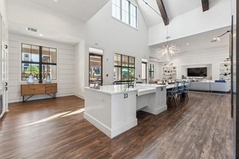 a white kitchen with a large island and a dining room table