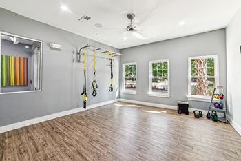 A room with a wooden floor and a wall-mounted exercise equipment at Proximity Apartments, Charleston, SC