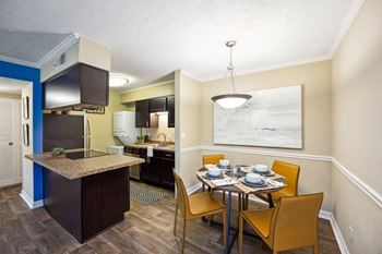 a dining room and kitchen with a table and chairs at The Grove at Lyndon, Louisville