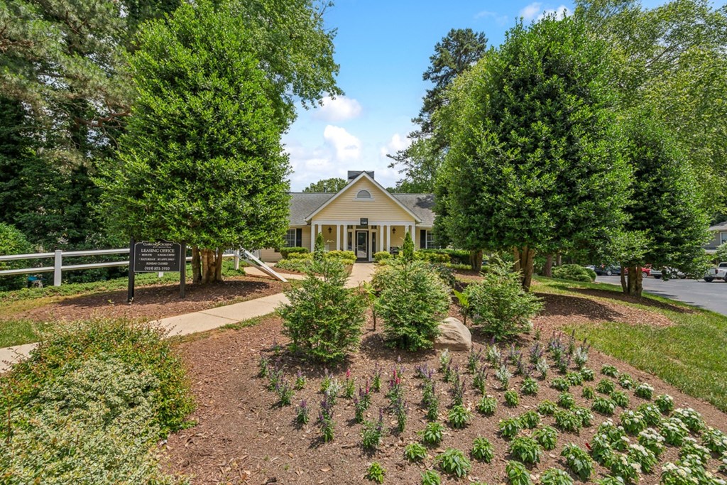 a garden in front of a house with a sign
