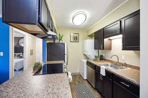a kitchen with a counter top and a sink and a refrigerator
