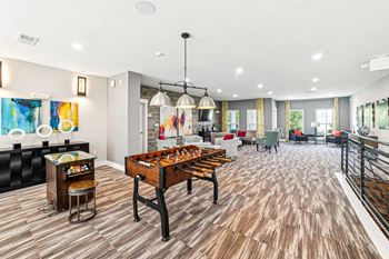 A room with a wooden floor and a pool table at Proximity Apartments, Charleston, SC