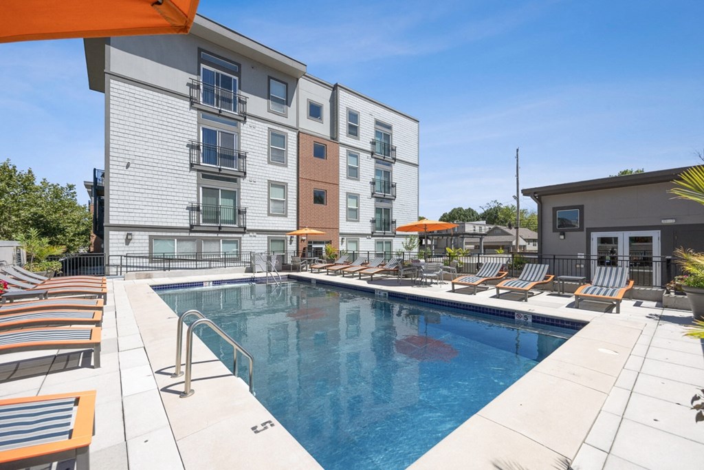 Swimming Pool with Chaise Lounge Chairs and Umbrellas in Front of a Building at 45 Madison Apartments, Missouri, 64111
