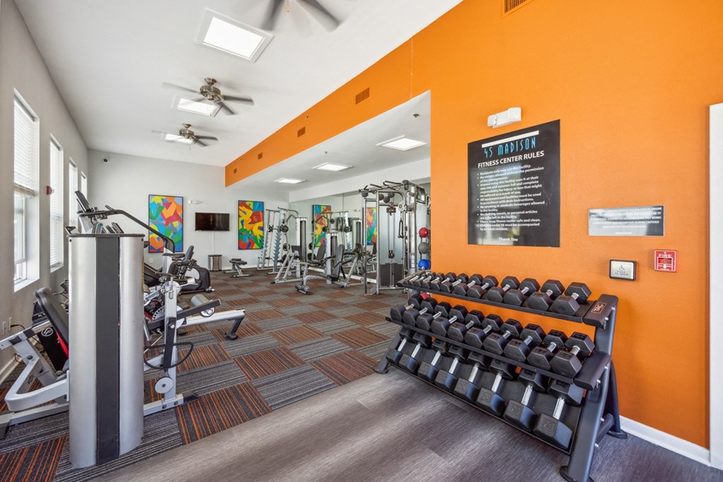 Spacious Fitness Center with Cardio Equipment and a Colorful Mural on the Wall at 45 Madison Apartments, Missouri, 64111