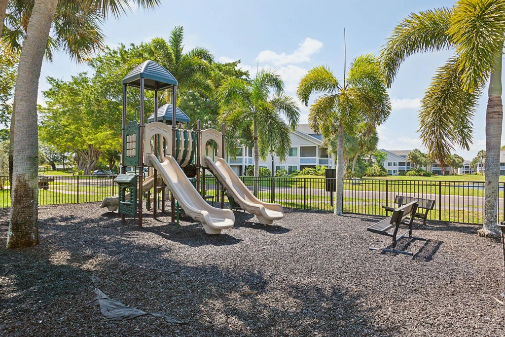 playground with slides and picnic tables in front of a house