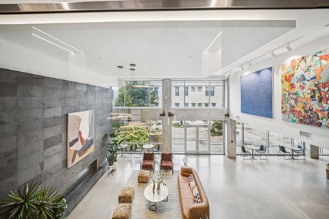 A modern living room with a grey wall and a painting on it.