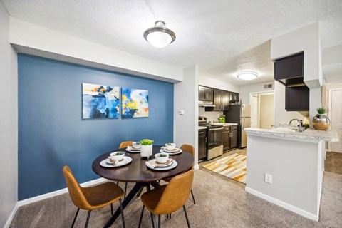 a dining room and kitchen with a table and chairs