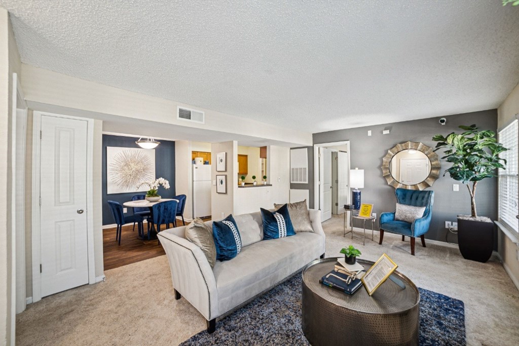 A living room with a couch, a coffee table, and a dining table at Willow Ridge Apartments, North Carolina, 28210
