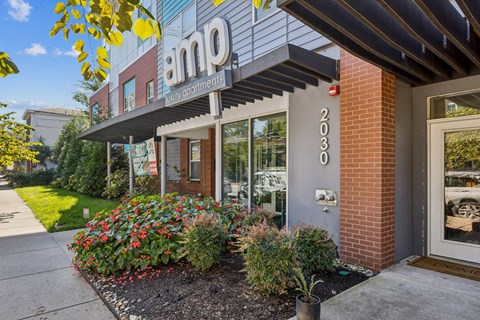 A building with a sign that reads "amp" in front of it.