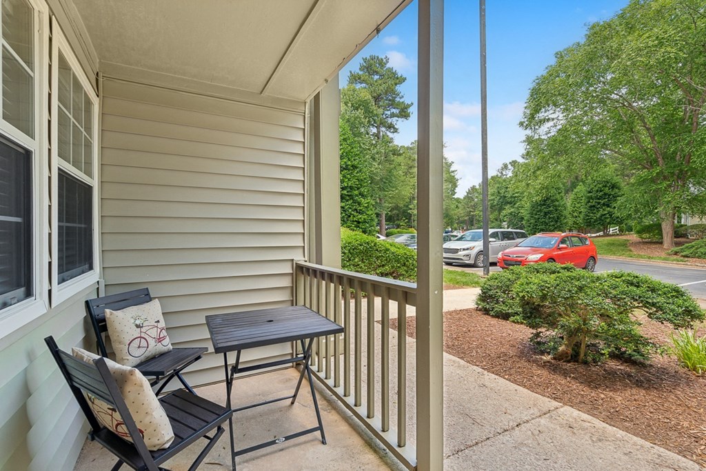 a patio with two chairs and a table on a porch