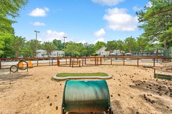 A playground with a green slide and orange swings.