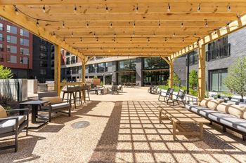 a large patio with chairs and tables under a wooden canopy at Hydro, Richmond, VA
