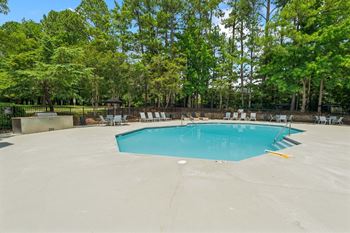 A large swimming pool surrounded by trees.