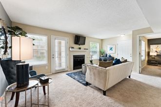 a living room with a couch and a chair in front of a fireplace