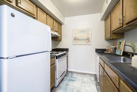 a kitchen with white appliances and wooden cabinets