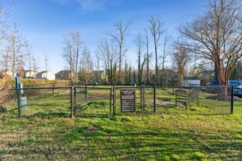 a dog park with a fence and a sign in the grass at Ashton Creek, Virginia