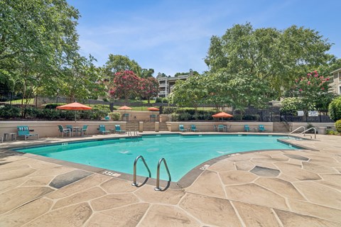 A swimming pool surrounded by trees and chairs at Beacon Ridge Apartments, PRG Real Estate Management, Greenville, 29615