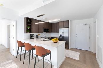 a kitchen with a large island with three stools at Hydro, Richmond, VA