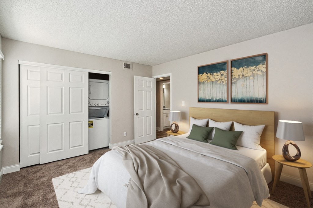 a bedroom with a large bed and two paintings on the wall at The Reserve At Barry Apartments, Kansas City, MO