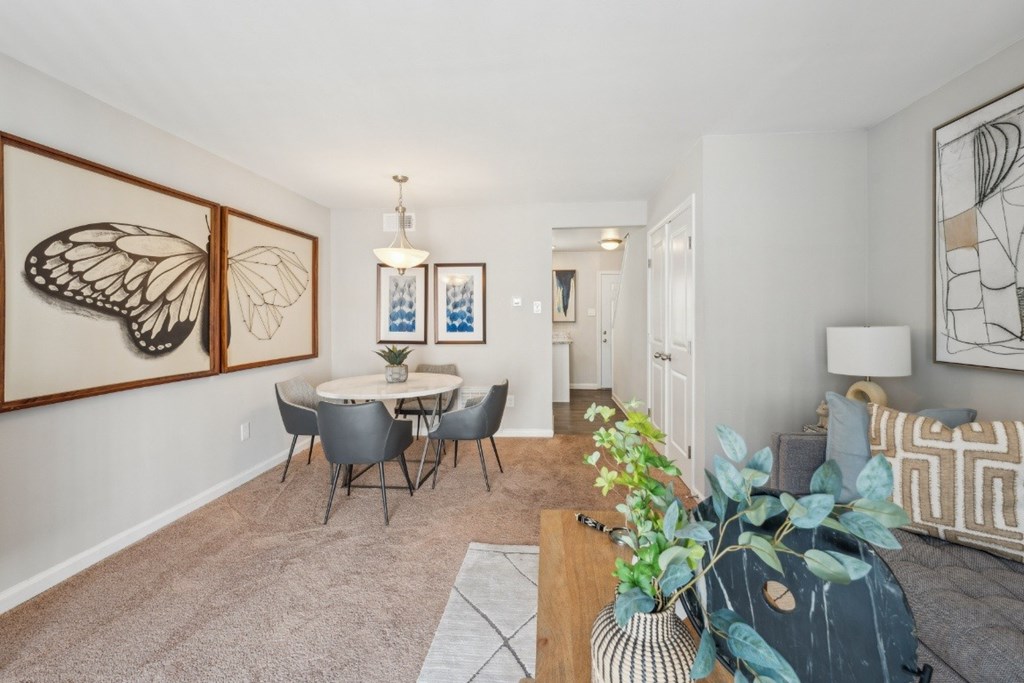 A living room with a dining table and chairs at Staples Mill Townhomes Apartments, Richmond