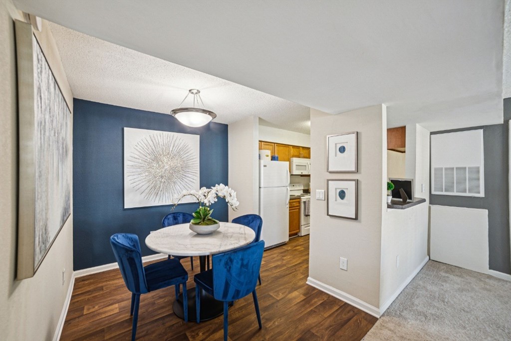 A dining room with a round table and blue chairs at Willow Ridge Apartments, North Carolina, 28210