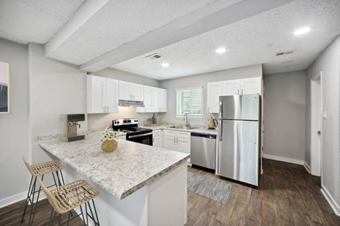 a kitchen with white cabinets and stainless steel appliances