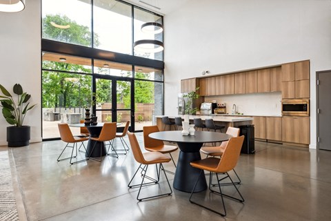 a dining area with a table and chairs and a kitchen with wood cabinets and stainless steel appliances