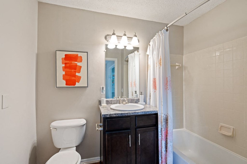 a bathroom with a toilet sink and shower and a mirror